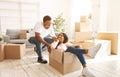 Black woman and her boyfriend playing together with cardboard box during relocation