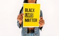 Black woman holds yellow poster with text - black lives matter. Black People Equality Concept. Closeup banner of protest.