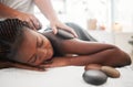 Black woman, hot stone massage, spa with hands of masseuse, holistic and wellness with treatment. Health, peace of mind Royalty Free Stock Photo