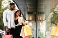 Black woman hugging man pointing at mall window Royalty Free Stock Photo