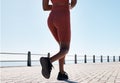 Black woman, legs and running for fitness at beach sidewalk, energy and strong summer body. Runner, healthy female and Royalty Free Stock Photo