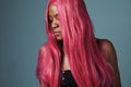 Black woman with long shiny straight pink hair.