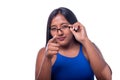 Black woman looking straight ahead with suspicious expression. Latin woman lowering her glasses and suspicious look Royalty Free Stock Photo