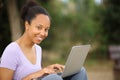 Black woman looks at you using laptop in a park Royalty Free Stock Photo