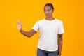 black woman makes stop gesture with hand on yellow background Royalty Free Stock Photo