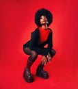 Black woman, makeup and afro, hair and fashion in portrait with shine isolated on red background. Hairstyle, haircare Royalty Free Stock Photo