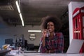 Black woman in modern office speeking on phone over earphones Royalty Free Stock Photo