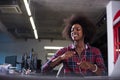 Black woman in modern office speeking on phone over earphones Royalty Free Stock Photo