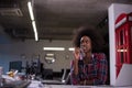 Black woman in modern office speeking on phone over earphones Royalty Free Stock Photo