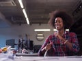 Black woman in modern office speeking on phone over earphones Royalty Free Stock Photo