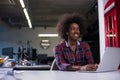 Black woman in modern office speeking on phone over earphones Royalty Free Stock Photo