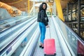 Black woman in the moving walkway at the airport with a pink sui Royalty Free Stock Photo