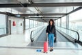 Black woman in the moving walkway at the airport with a pink sui Royalty Free Stock Photo