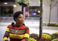 black woman with natural hair Afro is sitting outdoors on a beautiful summer day i Royalty Free Stock Photo