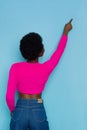 Black Woman In Neon Color Pink Sweater Is Pointig Up. Rear View