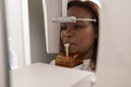 A black woman patient standing at the x-rays machine at the dental clinic