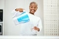 Black woman, pitcher and glass with water filter for clean and fresh purification at home. Happy female person pouring Royalty Free Stock Photo