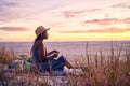 Black woman, relax and book on beach in sunset with diary or journal for vacation in nature outdoors. African female Royalty Free Stock Photo