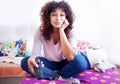 One black woman holding television remote and zapping channels