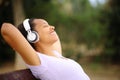 Black woman relaxing listening music in a park Royalty Free Stock Photo