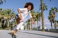 Black woman on roller skates rollerblading in beach promenade wi