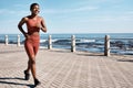 Black woman running at beach promenade for fitness, energy and strong summer body. Runner, healthy female and sports Royalty Free Stock Photo