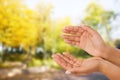 Black Woman`s hand two palm up. handbreadth on blurred park background. Front view. Mock up. Copy space