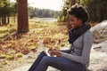Black woman sitting on a rock in countryside using computer Royalty Free Stock Photo