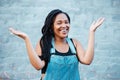 Black woman, smile and hands for confused or unsure gesture posing outside against urban city background in street