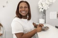 A black woman smiles with joy while keeping the invoice of the dental clinic