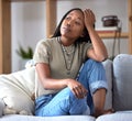 Black woman, sofa and stress with worry, thinking and sad in home living room with fear of future. African woman Royalty Free Stock Photo