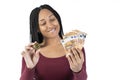 Black woman with some fifty euro bills shows a bitcoin on a white background