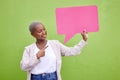 Black woman, speech bubble and thinking for pointing, space or mockup with opinion by green wall background. African