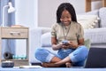 Black woman, student and phone with smile for social media, chatting or texting sitting on floor in living room. Happy Royalty Free Stock Photo