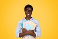 A black woman student, surrounded by books, displays a look of dedication and intellect