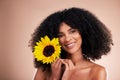 Black woman, studio portrait and sunflower with smile, beauty and cosmetic wellness by beige background. African gen z Royalty Free Stock Photo