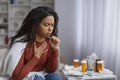 Black woman suffering cold, sitting wrapped in blanket and coughing at home Royalty Free Stock Photo