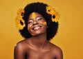 Black woman, sunflower and paint in studio with makeup for beauty with creative, confidence and spring. Cosmetics Royalty Free Stock Photo