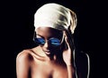 Black woman, sunglasses and headscarf with fashion for style on a dark studio background. Face of young African female Royalty Free Stock Photo