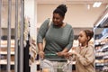 Black woman in supermarket shopping for groceries with little girl Royalty Free Stock Photo