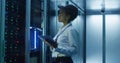 Black woman with tablet working in server room