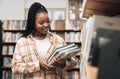 Black woman, university student and library with books for education, learning and knowledge at campus. Happy, smile and Royalty Free Stock Photo