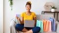 Black woman using laptop and credit card on the couch Royalty Free Stock Photo