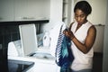 Black woman using washing machine doing the laundry Royalty Free Stock Photo