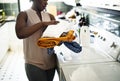 Black woman using washing machine doing the laundry Royalty Free Stock Photo