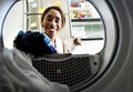 Black woman using washing machine doing the laundry Royalty Free Stock Photo