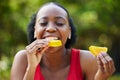 Black woman, vitamin C and eating orange slice for natural nutrition or citrus diet in nature outdoors. Happy African Royalty Free Stock Photo