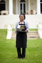 Black woman, waitress and carrying wine in garden, vinyard or resort in the countryside. Happy African female person Royalty Free Stock Photo