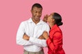 Black woman whispering to smiling man, sharing secrets