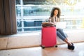 Black woman working with laptop at the airport waiting at the wi Royalty Free Stock Photo